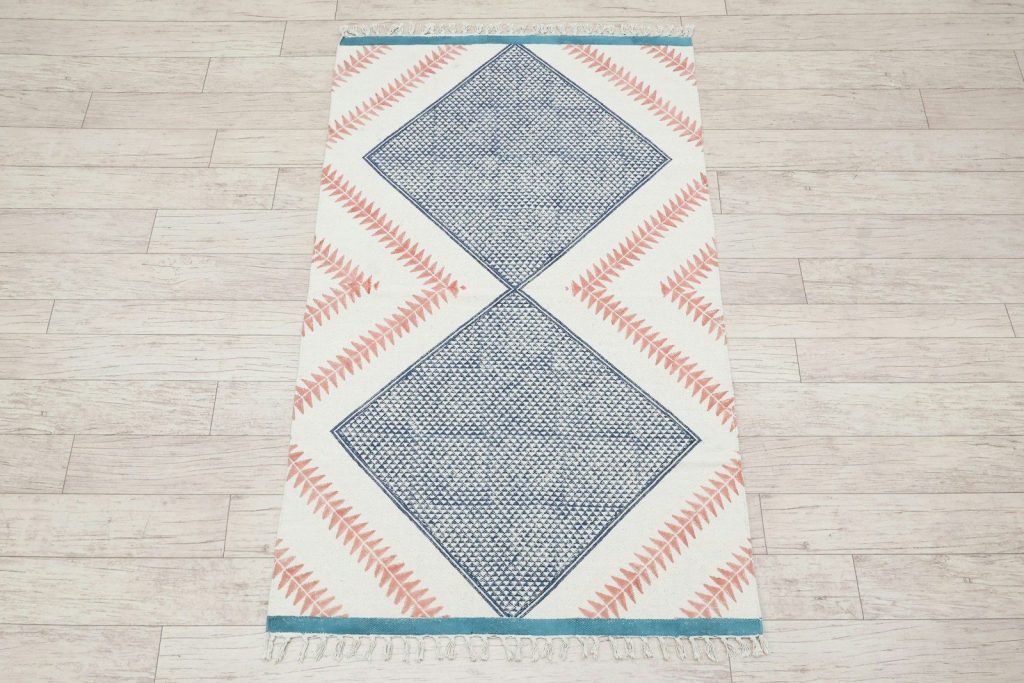 A geometric patterned rug on a wooden floor