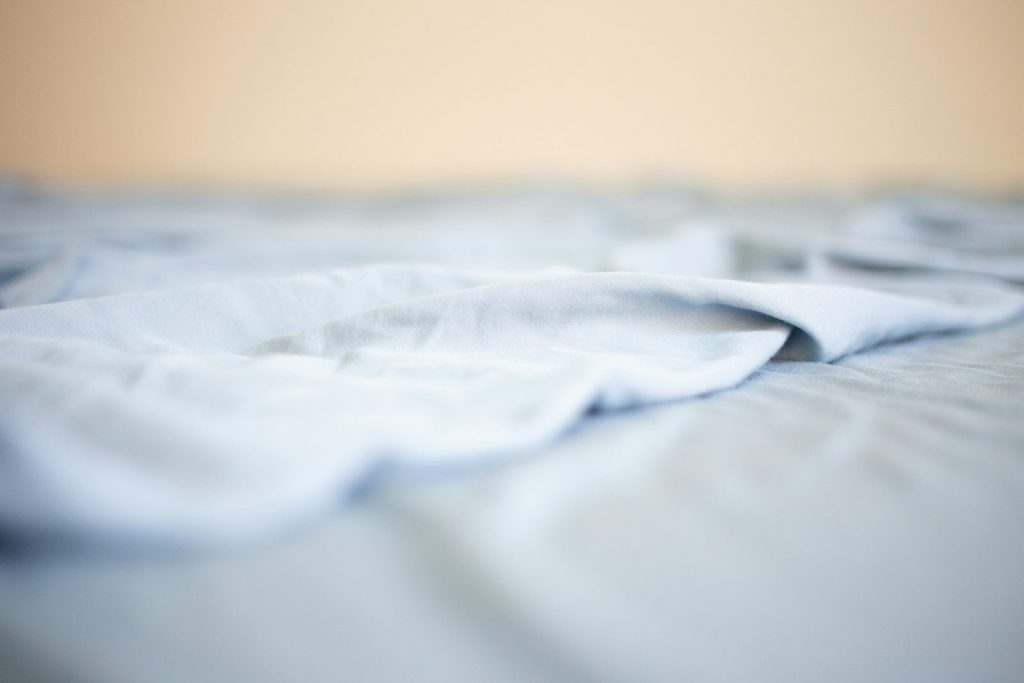 a close up of a white sheet on a bed