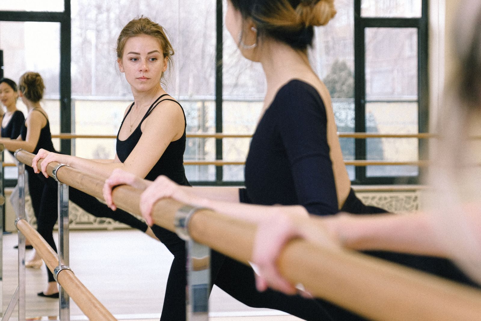 Women practicing ballet in an indoor studio during a training session.