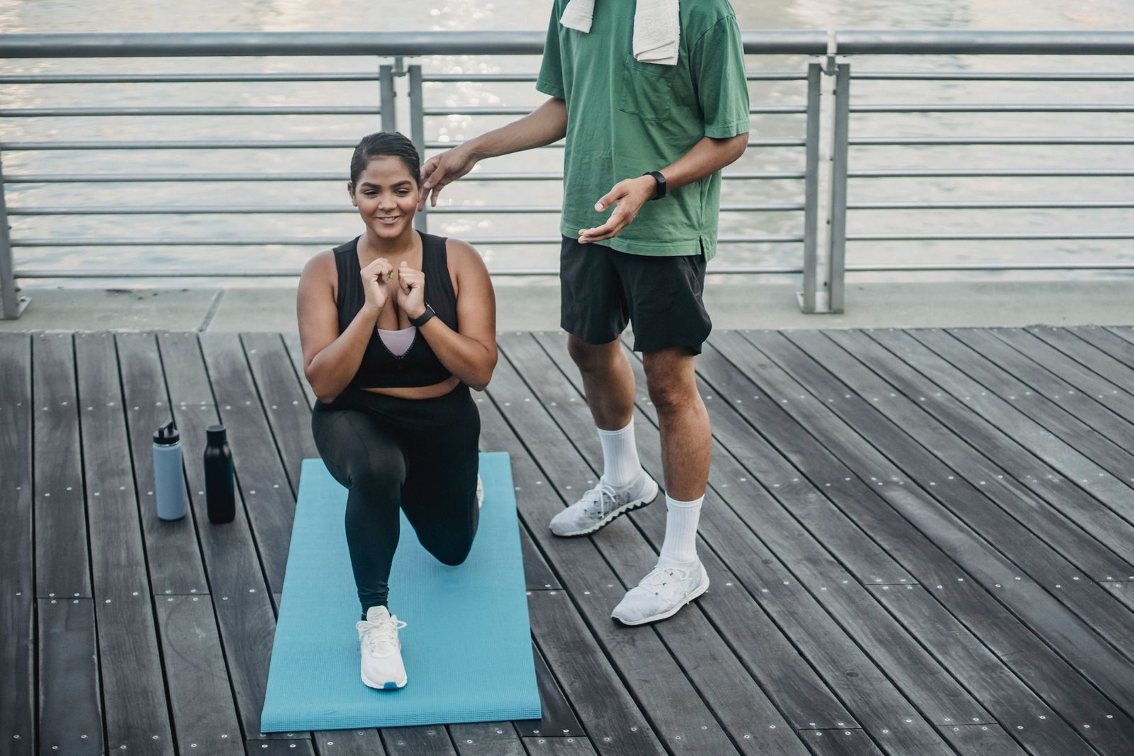 A woman doing lunges on a yoga mat outdoors with guidance.