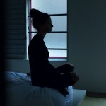 woman sitting on bed